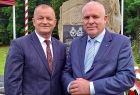 Wicemarszałek Ryszard Pagacz stoi z mężczyzną. Za nimi widoczny pomnik.
