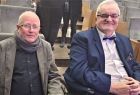 Dwóch starszych panów siedzi na widowni.