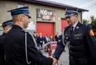Wicemarszałek Łukasz Smółka ściska dłoń strażakowi.