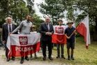 Wicemarszałek Ryszard Pagacz stoi z ludźmi trzymającymi flagi z napisem Polska. 