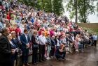 Ludzie siedzą na trybunach amfiteatru.