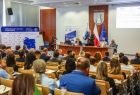 Sala w której odbywały się obrady. Widoczny stół, a na pierwszym planie siedzą ludzie na widowni.