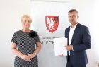 Podpisaną umowę prezentują członek zarządu województwa Iwona Gibas oraz burmistrz Miechowa Iwona Gibas