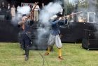 Żołnierze w strojach historycznych strzelają z broni.