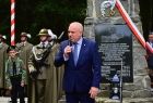 Wicemarszałek Ryszard Pagacz stoi przed pomnikiem.