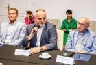 Trzech profesorów siedzi przy stole.