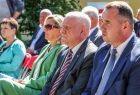 Wicemarszałek Ryszard Pagacz siedzi na widowni, obok siedzą inni ludzie.