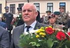Wicemarszałek Ryszard Pagacz trzyma wiązankę kwiatów.