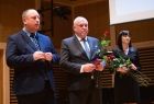 Wicemarszałek Ryszard Pagacz stoi z wojewodą i kobietą na scenie.