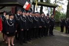 Strażacy ochotnicy stojący przed kościołem w Porębie Wielkiej