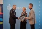 Iwona Gibas z Zarządu Województwa Małopolskiego oraz burmistrz Chrzanowa Robert Maciaszek przekazujący zakupiony przez samorządy sprzęt, w tym specjalistyczne ubrania, strażakom ochotnikom
