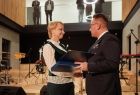 Burmistrz Trzebini Jarosław Okoczuk przekazuje Iwonie Gibas z zarządu województwa okolicznościowy upominek z okazji otwarcia Manufaktury Trzebinia