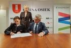 Wójt gmin Osiek Marek Jasiński, prezeska miejscowej OSP oraz Iwona Gibas z zarządu województwa. Chwila podpisania umowy o przekazaniu sprzętu