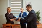 Iwona Gibas z zarządu województwa przekazuje symboliczny świąteczny upominek wójtowi Przeciszowa Tomaszowi Kosowskiemu oraz prezesowi OSP Przeciszów Rafałowi Madei 
