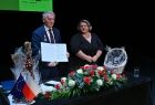 Mężczyzna prezentujący podpisaną umowę. Obok kobieta.