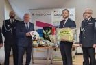 Wicemarszałek Ryszard Pagacz stoi ze strażakami w sali.