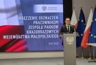 Mężczyzna w garniturze przy mównicy.