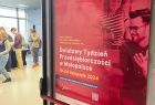Plakat Światowego Tygodnia Przedsiębiorczści wiszący na drzwiach miejsca w którym odbywa się hackathon. 