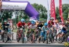 Dzieci jadą na rowerach. Za nimi napis Małopolska Arena Mistrzostw.
