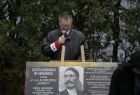 Mężczyzna z mikrofonem za tablicą upamiętniającą Kpt/Mjr Juliana Zapałę „Lamparta”.