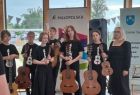 Młodzież szkolna z zespołu muzycznego trzymająca w rękach instrumenty muzyczne 