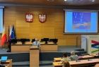 Mężczyzna przemawiający z ambony na auli.