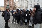 Uczestnicy wycieczki z przewodnikiem na rynku w Krakowie 