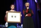 Iwona Gibas z Zarządu Województwa Małopolskiego oraz radna województwa Lidia Gądek wręczające nagrodę samorządu województwa dla Zespołu Pieśni i Tańca Wolbromiacy 