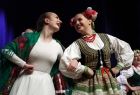 Roześmiane dziewczęta w strojach ludowych podczas występu na scenie 