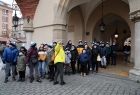 Przewodnik opowiada o historii krakowskiego rynku uczestnikom wycieczki 