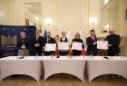 Uczestnicy spotkania w Filharmonii Krakowskiej prezentują podpisany uroczyście list intencyjny