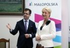 Iwona Gibas z Zarządu Województwa Małopolskiego oraz burmistrz Wolbromia Radosław Kuś stojący razem na tle baneru Małopolski 