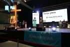 Członek zarządu Marta Malec-Lech oraz kapłan na scenie z krzyżem i ikoną.