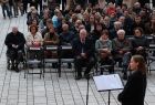 Wicemarszałek Ryszard Pagacz siedzący na widowni na dziedzińcu. 