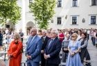 Grupa osób stojąca na placu.