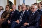 Grupa osób siedząca na sali.