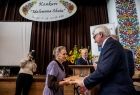 Wicemarszałek Józef Gawron wręcza dyplom starszej kobiecie.