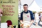 Marszałek Łukasz Smółka trzymający jabłka w dłoniach.