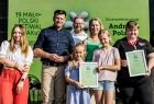 Marszałek Łukasz Smółka z kobietą z dziećmi na scenie.