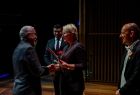 Iwona Gibas z zarządu województwa oraz marszałek Łukasz Smółka wręczający pracownikom okolicznościowe dyplomy i kwiaty