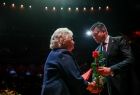 Marszałek Łukasz Smółka wręczający różę członkini zespołu Opery Krakowskiej