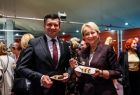 Marszałek Łukasz Smółka i Iwona Gibas z zarządu województwa trzymający talerzyki z kawałkami jubileuszowego tortu