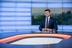 Marszałek Łukasz Smółka przy stole telewizyjnym.