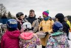 Marta Malec-Lech z zarządu województwa stoi z dziećmi i rozdaje odblaski. Wszyscy są uśmiechnięci. 