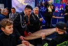 Marszałek Łukasz Smółka pomagający chłopcu z młodzieżowej drużyny pożarniczej