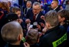 Poseł Andrzej Adamczyk łamiący się opłatkiem z członkami młodzieżowej drużyny strażackiej