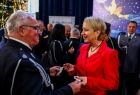 Iwona Gibas z zarządu województwa dzieląca się opłatkiem i składająca życzenia strażakowi