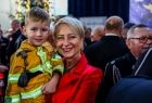 Iwona Gibas z zarządu województwa trzymająca na ręku chłopca w strażackim uniformie