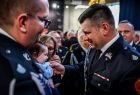 Marszałek Łukasz Smółka podczas serdecznej rozmowy ze strażakiem, który uczestniczy w uroczystości wraz z małym dzieckiem 