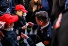 Marszałek Łukasz Smółka dzielący się opłatkiem z najmłodszymi uczestnikami wydarzenia